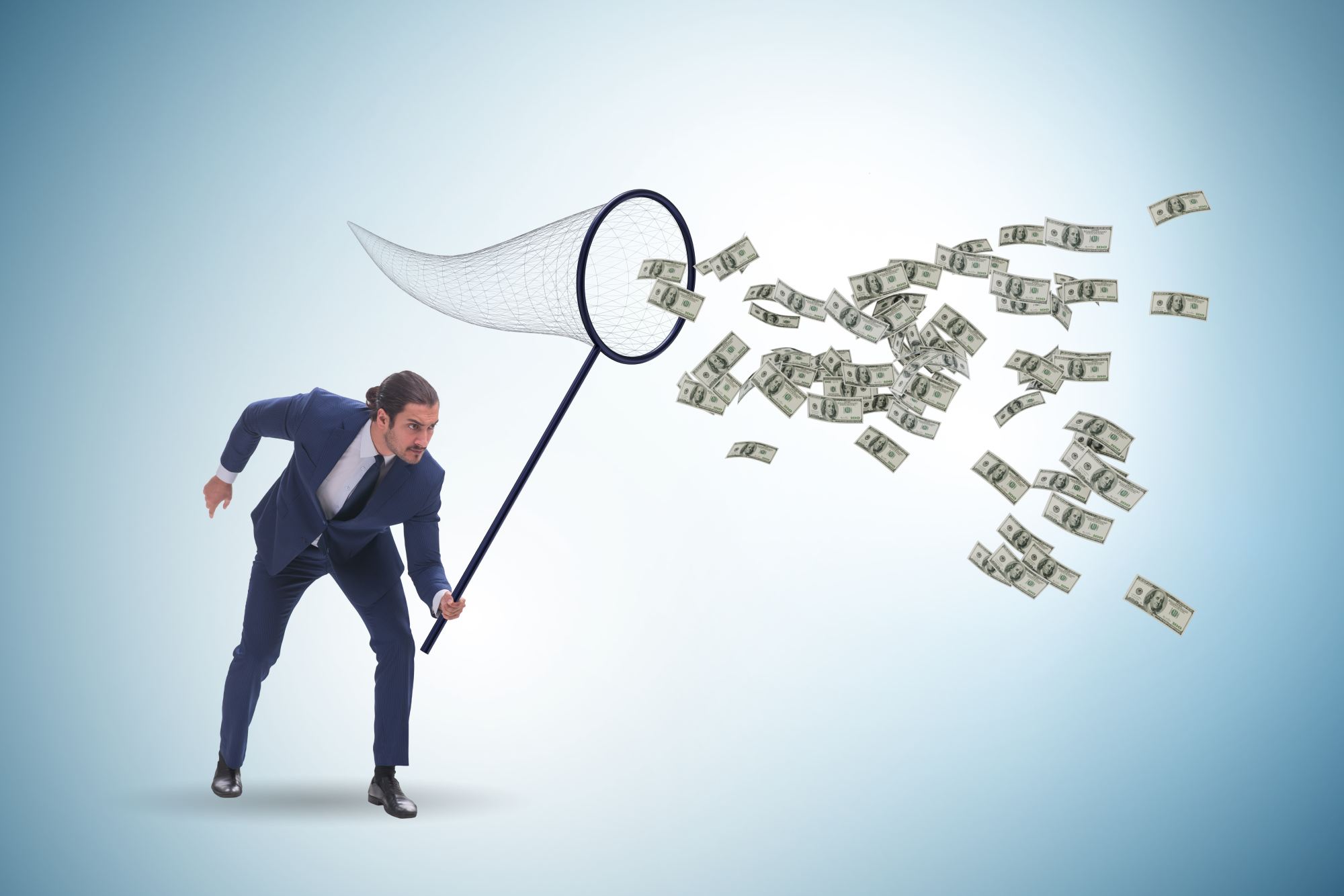 Young businessman catching dollars with the landing net