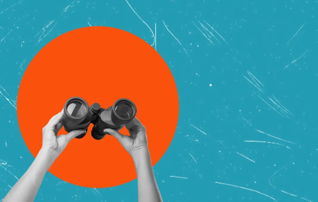 Hands holding binoculars on a blue background