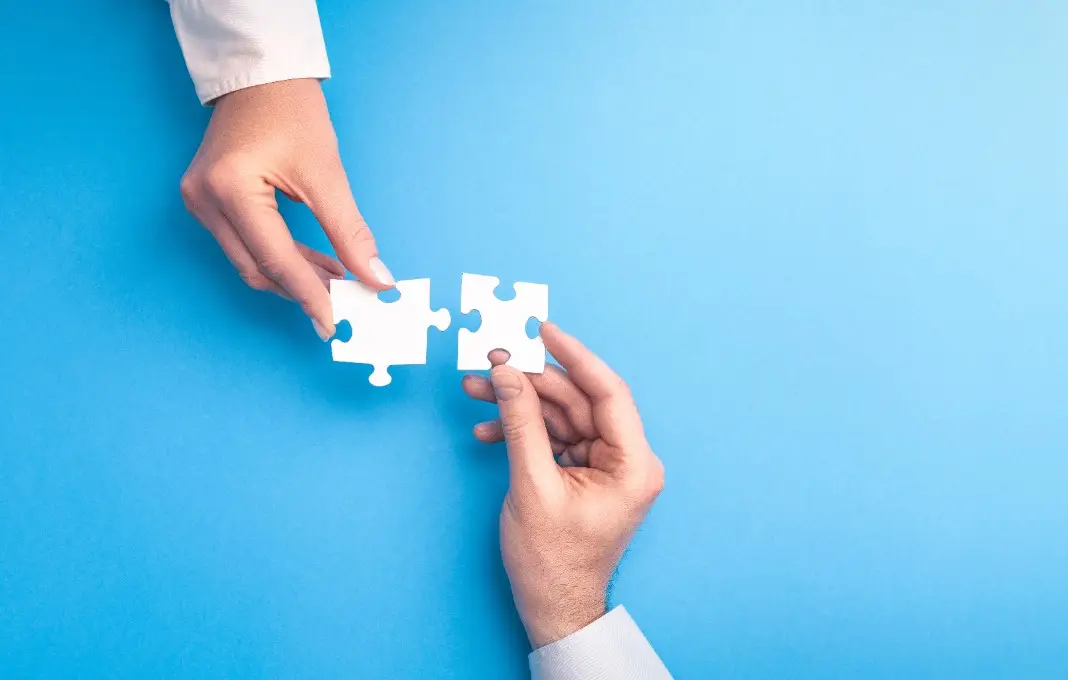 People holds in hand a jigsaw puzzle.