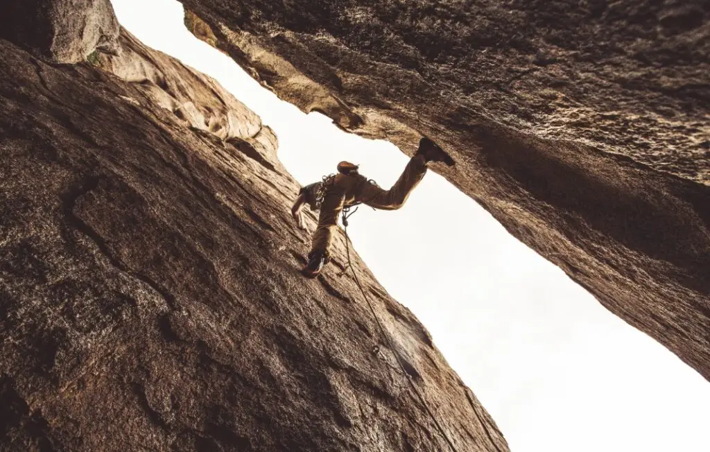 Rock climber in a canyon, pressing between two walls.